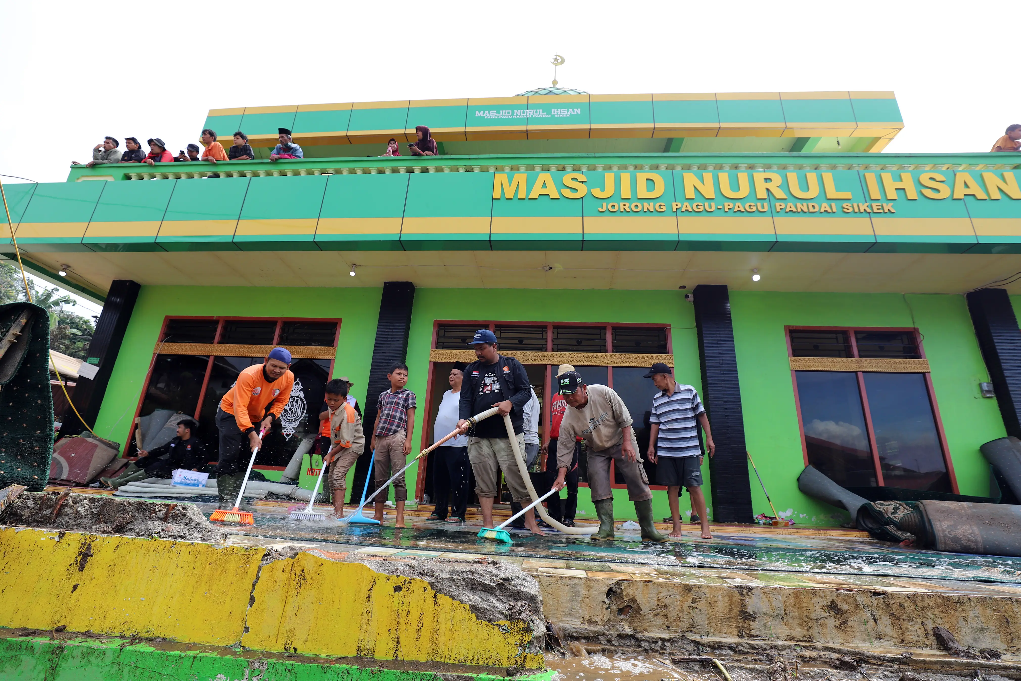 Tim gabungan bersama masyarakat Pandai Sikek saling bahu membahu melakukan pembersihan materiil akibat banjir lahar hujan dan tanah longsor yang melanda wilayah Pandai Sikek, Kabupaten Tanah Datar, Sumatra Barat, pada Selasa (14/5).